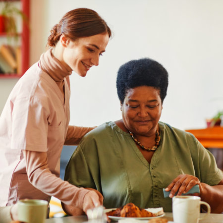 carer assisting senior woman at home