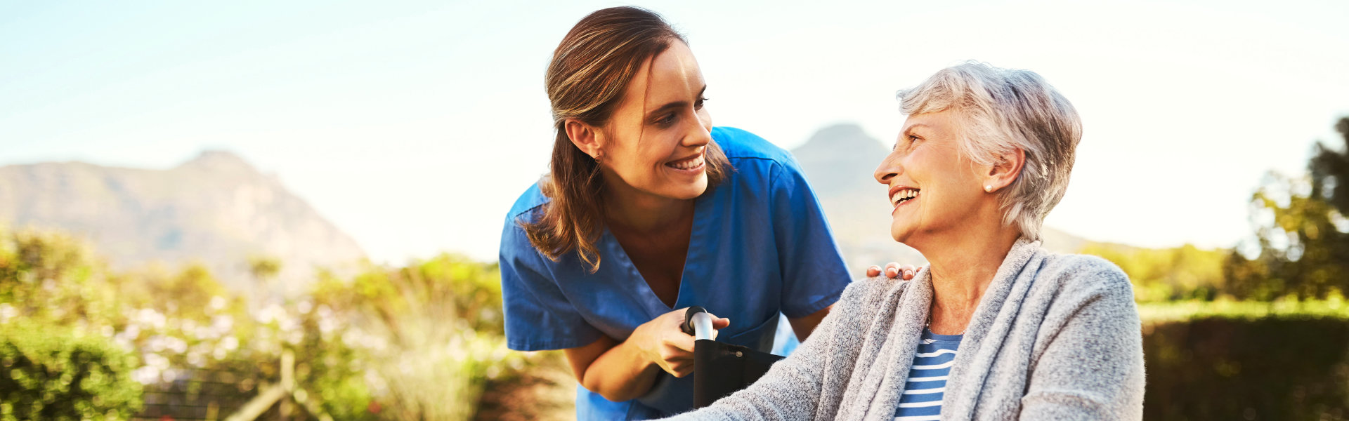 carer and senior woman smiling at each other