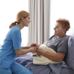 carer comforting senior woman