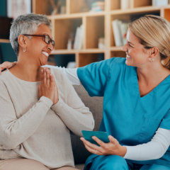 caregiver and senior woman smiling at each other