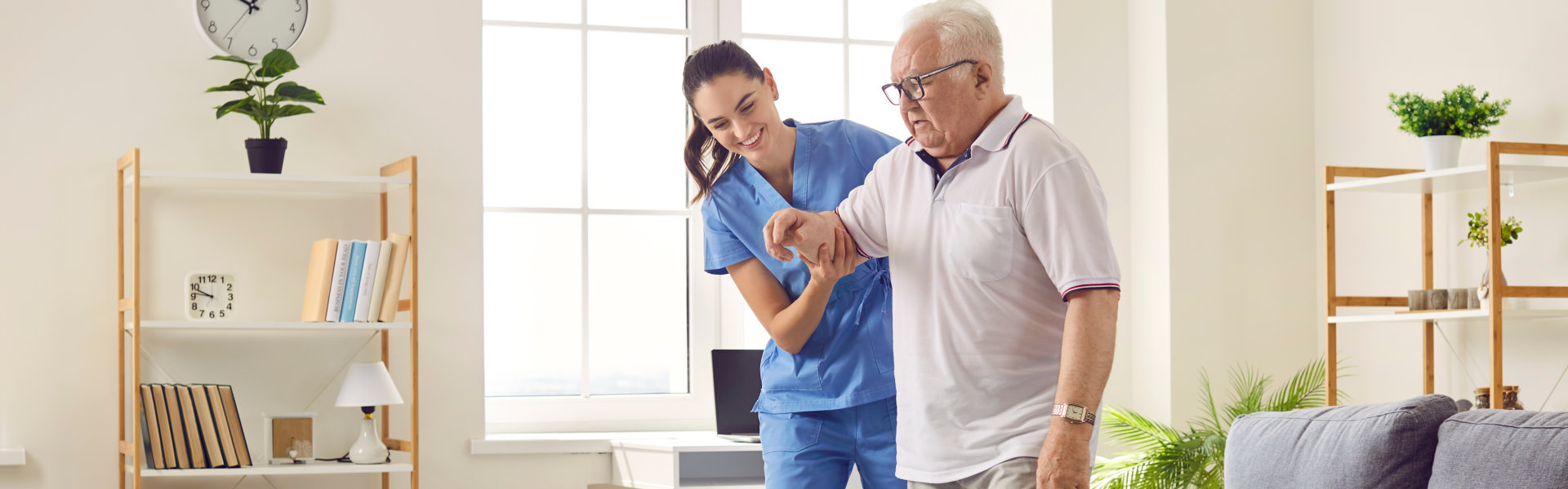 caregiver helping senior man to walk